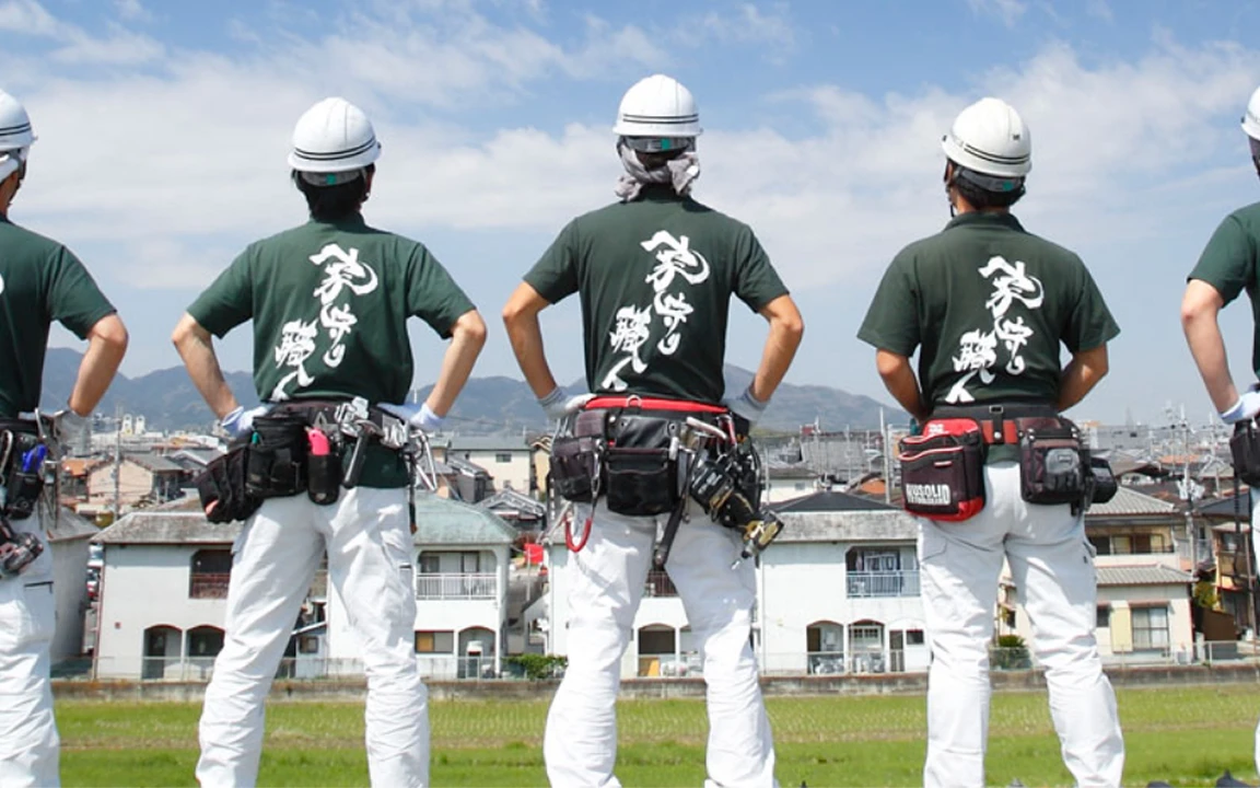 創業の地で屋根に向き合う職人たちの後ろ姿